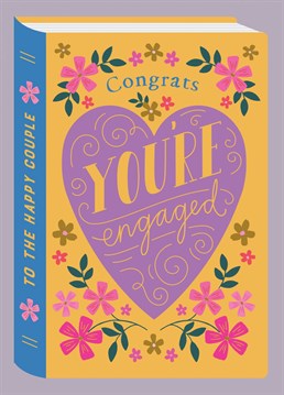 A fresh, beautiful design featuring flowers and hand drawn typography. It reads "Congrats on Your Engagement" on a beautiful yellow background, with a purple heart. This Congratulations Card is designed to look like a hardback book and the details add a touch of luxury!